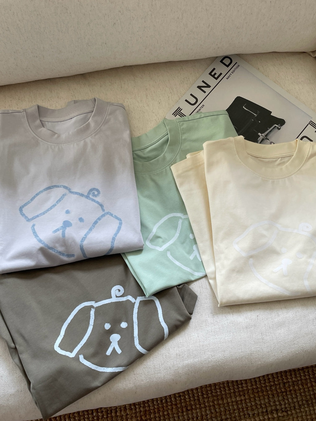 Folded Wipeaway 245g cotton-blend tees showing the minimalist puppy logo, perfect for everyday casual streetwear.