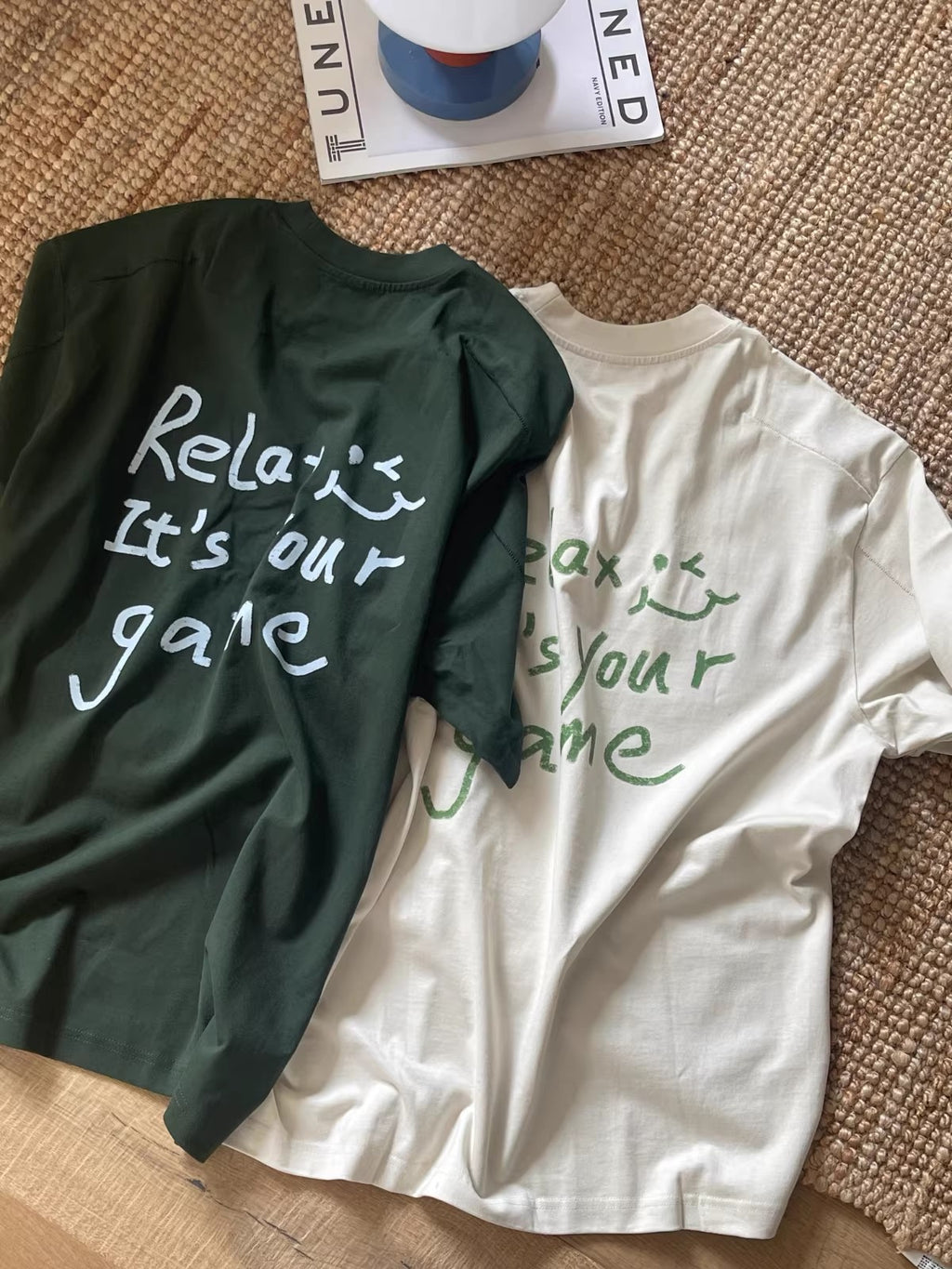 Back view of the Wipeaway drop-shoulder tee showing the hand-drawn text "Relax, it's your game" with vintage flatlock stitching details.